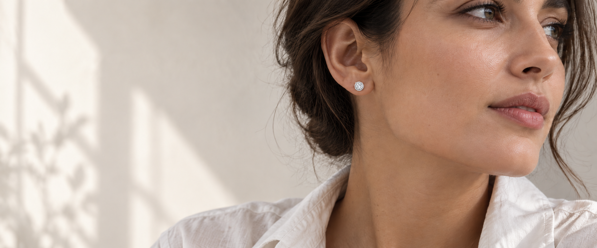 A woman wearing a round diamond stud earring